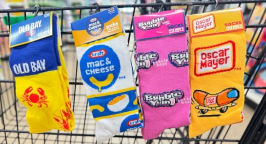 Novelty socks shown on the cart of dollar tree including old bay Mac & cheese bubble gum