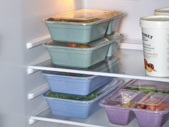 green and blue stackable food containers in a fridge