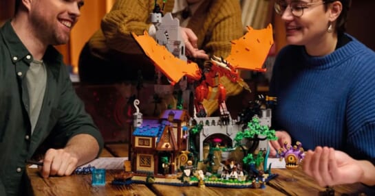 people sitting at table with dungeons and dragons lego set